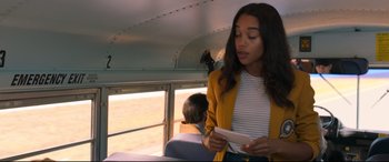 Movie still from “Spider-Man: Homecoming” (2017), directed by Jon Watts – A woman in a yellow jacket holding a piece of paper on a bus; Medium shot, Over the shoulder angle
