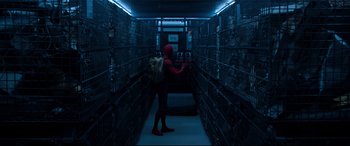 Movie still from “Spider-Man: Homecoming” (2017), directed by Jon Watts – A man in a red suit is standing in a dark room; Wide shot, High angle