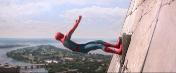 Movie still from “Spider-Man: Homecoming” (2017), directed by Jon Watts – A man dressed as spider - man hangs from a rope; Wide shot, Low angle