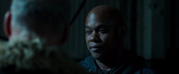 Movie still from “Spider-Man: Homecoming” (2017), directed by Jon Watts – A man with a bald head is looking into the camera; Close Up shot, Over the shoulder angle