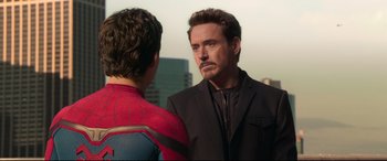 Movie still from “Spider-Man: Homecoming” (2017), directed by Jon Watts – A man in a black jacket is talking to a man in a spider - man costume; Close Up shot, Over the shoulder angle