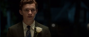 Movie still from “Spider-Man: Homecoming” (2017), directed by Jon Watts – A man in a suit and tie holding a white rose; Close Up shot, Over the shoulder angle