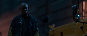 Movie still from “Spider-Man: Homecoming” (2017), directed by Jon Watts – A man in a black jacket is standing in a dark room; Close Up shot, Over the shoulder angle