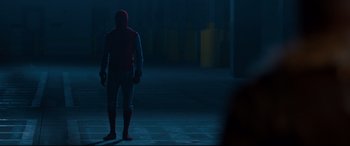Movie still from “Spider-Man: Homecoming” (2017), directed by Jon Watts – A man standing in the middle of a street at night; Wide shot, Over the shoulder angle
