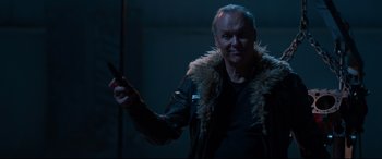 Movie still from “Spider-Man: Homecoming” (2017), directed by Jon Watts – A man in a black jacket holding a gun; Close Up shot, Over the shoulder angle