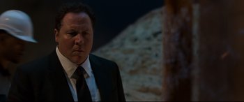 Movie still from “Spider-Man: Homecoming” (2017), directed by Jon Watts – A man wearing a suit and tie standing next to a tree; Close Up shot, Over the shoulder angle