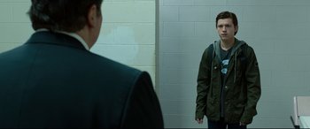 Movie still from “Spider-Man: Homecoming” (2017), directed by Jon Watts – A man standing in front of a mirror in a room; Medium shot, Over the shoulder angle