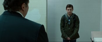 Movie still from “Spider-Man: Homecoming” (2017), directed by Jon Watts – A man standing in front of a wall in a room; Medium shot, Over the shoulder angle