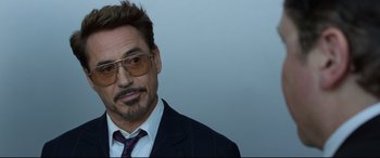 Movie still from “Spider-Man: Homecoming” (2017), directed by Jon Watts – A person wearing a suit and sunglasses; Close Up shot, Over the shoulder angle