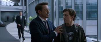 Movie still from “Spider-Man: Homecoming” (2017), directed by Jon Watts – A man in a suit and tie holding a man in a jacket; Close Up shot, Over the shoulder angle