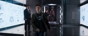 Movie still from “Spider-Man: Homecoming” (2017), directed by Jon Watts – A group of people standing in a room; Medium shot, Over the shoulder angle