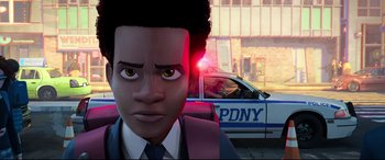 Movie still from “Spider-Man: Into the Spider-Verse” (2018), directed by Peter Ramsey – A man in a suit and tie in front of a cop car; Close Up shot, Over the shoulder angle