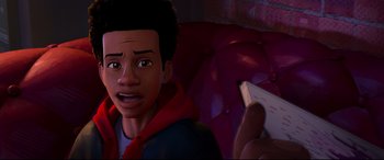 Movie still from “Spider-Man: Into the Spider-Verse” (2018), directed by Peter Ramsey – A young boy is looking at a video game controller; Close Up shot, Over the shoulder angle