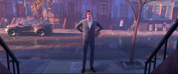 Movie still from “Spider-Man: Into the Spider-Verse” (2018), directed by Peter Ramsey – An animated man standing on the sidewalk in front of a building; Wide shot, Over the shoulder angle
