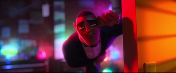 Movie still from “Spies in Disguise” (2019), directed by Troy Quane – A man with a red mask is standing in a room with lights in the background; Medium shot, Low angle