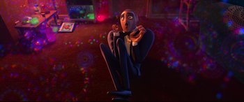 Movie still from “Spies in Disguise” (2019), directed by Troy Quane – A man sitting on the ground with his hands on his knees; Medium shot, High angle