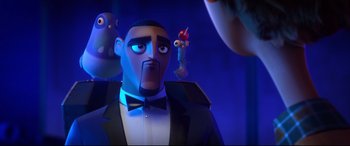 Movie still from “Spies in Disguise” (2019), directed by Troy Quane – A man in a suit and bow tie is looking into the camera; Close Up shot, Over the shoulder angle
