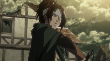 Movie still from “Attack on Titan” (2013), directed by Masashi Koizuka – A man with long black hair and a bandage on his head; Medium shot, Low angle