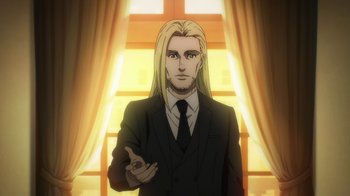 Movie still from “Attack on Titan” (2013), directed by Masashi Koizuka – A man with long blonde hair wearing a suit and tie; Medium shot, Over the shoulder angle