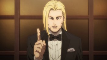 Movie still from “Attack on Titan” (2013), directed by Masashi Koizuka – A man with long blonde hair wearing a suit and bow tie; Close Up shot, Low angle