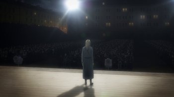 Movie still from “Attack on Titan” (2013), directed by Masashi Koizuka – A woman standing in front of an audience at night; Extreme Wide shot, High angle