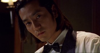 A person with long hair wearing a bow tie