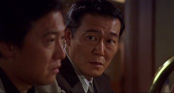 A man in a suit and tie next to another man in a suit and tie