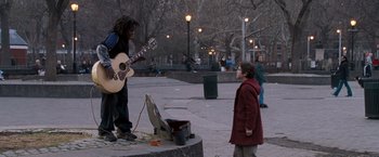 Movie still from “August Rush” (2007), directed by Kirsten Sheridan – A man playing a guitar in front of a woman; Wide shot, Over the shoulder angle