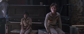 Movie still from “August Rush” (2007), directed by Kirsten Sheridan – Two young people sitting next to each other in front of a piano; Medium shot, Over the shoulder angle