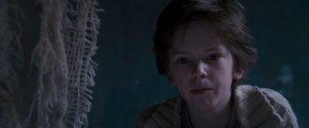 Movie still from “August Rush” (2007), directed by Kirsten Sheridan – A young boy is looking into the camera; Close Up shot, Over the shoulder angle