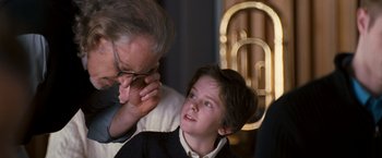 Movie still from “August Rush” (2007), directed by Kirsten Sheridan – An older man adjusting a young boy's glasses; Close Up shot, Over the shoulder angle