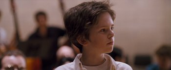 Movie still from “August Rush” (2007), directed by Kirsten Sheridan – A young boy is looking to his left; Close Up shot, Low angle