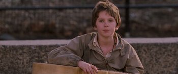 Movie still from “August Rush” (2007), directed by Kirsten Sheridan – A young boy sitting on the ground with a guitar in front of him; Close Up shot, Over the shoulder angle