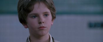 Movie still from “August Rush” (2007), directed by Kirsten Sheridan – A young boy with blue eyes stares into the distance; Close Up shot, Low angle