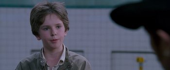Movie still from “August Rush” (2007), directed by Kirsten Sheridan – A young boy is standing in front of a wall; Close Up shot, Over the shoulder angle