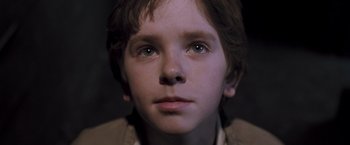 Movie still from “August Rush” (2007), directed by Kirsten Sheridan – A young boy's face in the dark; Close Up shot, Low angle
