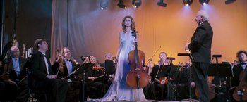 Movie still from “August Rush” (2007), directed by Kirsten Sheridan – A woman in a white dress is holding a cello; Wide shot, Low angle