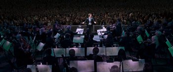 Movie still from “August Rush” (2007), directed by Kirsten Sheridan – A man is standing in front of an orchestra; Wide shot, High angle