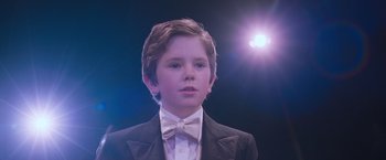 Movie still from “August Rush” (2007), directed by Kirsten Sheridan – A young boy in a suit and bow tie; Close Up shot, Low angle