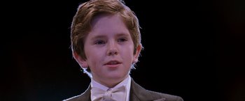 Movie still from “August Rush” (2007), directed by Kirsten Sheridan – A young boy in a suit and bow tie; Close Up shot, Low angle