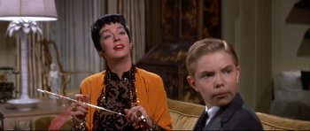 Movie still from “Auntie Mame” (1958), directed by Morton DaCosta – An older woman and a young boy sitting on a couch; Close Up shot, Over the shoulder angle