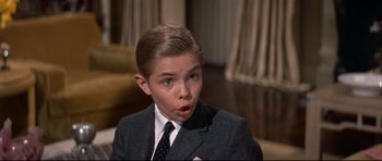 Movie still from “Auntie Mame” (1958), directed by Morton DaCosta – A boy in a suit and tie looking surprised; Close Up shot, High angle