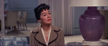 Movie still from “Auntie Mame” (1958), directed by Morton DaCosta – An older woman wearing a brown jacket and pearls; Close Up shot, Over the shoulder angle