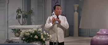 Movie still from “Auntie Mame” (1958), directed by Morton DaCosta – A man holding a phone up to his ear; Medium shot, Low angle