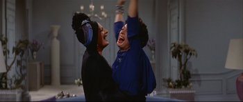 Movie still from “Auntie Mame” (1958), directed by Morton DaCosta – Two women are laughing together in a room; Medium shot, Low angle