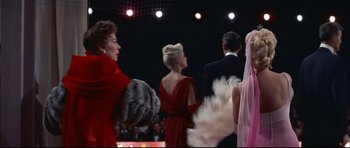 Movie still from “Auntie Mame” (1958), directed by Morton DaCosta – A group of women in red dresses standing next to each other; Medium shot, Low angle