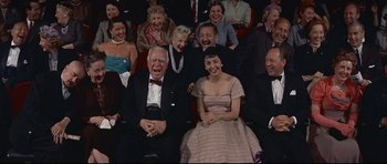 Movie still from “Auntie Mame” (1958), directed by Morton DaCosta – A group of people sitting in a theater; Medium shot, High angle