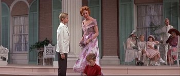 Movie still from “Auntie Mame” (1958), directed by Morton DaCosta – A woman and two boys in front of a building; Medium shot, Low angle