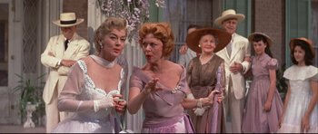 Movie still from “Auntie Mame” (1958), directed by Morton DaCosta – A group of women standing next to each other; Medium shot, Over the shoulder angle