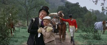 Movie still from “Auntie Mame” (1958), directed by Morton DaCosta – A woman and a boy are hugging on the side of the road; Medium shot, Low angle